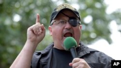 FILE - In this June 25, 2017, photo, Stewart Rhodes, founder of the citizen militia group known as the Oath Keepers, speaks during a rally outside the White House in Washington. 
