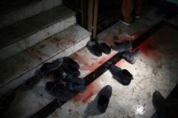 FILE - Blood stains and shoes remain on stairs inside a Sikh house of worship, in the aftermath of an attack on Sikh believers, in Kabul, Afghanistan, March 25, 2020.