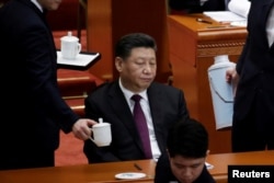 An attendant serves tea for Chinese President Xi Jinping at the opening session of the Chinese People's Political Consultative Conference (CPPCC) at the Great Hall of the People in Beijing, China March 3, 2019.