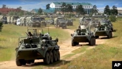 In this frame grab provided by Russian Defense Ministry Press Service on Tuesday, Sept. 11, 2018, Russian armored personnel carriers roll during the military exercises in the Chita region, Eastern Siberia, during the Vostok 2018 exercises in Russia.