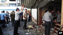 Foto yang dirilis oleh kantor berita Suriah, SANA, ini menunjukkan warga tengah memeriksa toko yang rusak akibat ledakan bom di pusat wilayah al-Marjeh, Damaskus, Suriah (11/6).