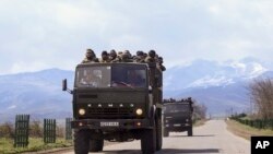 Pejuang Armenia berdiri di truk bak terbuka menuju garis depan di provinsi Martakert, wilayah separatis Nagomo-Karabakh, Azerbaijan (4/4). 