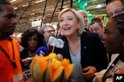French far-right leader Marine le Pen smiles at the French Caraibean islands stand as she visits the Agriculture Fair, Feb. 28, 2017, in Paris.