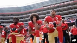 From left, San Francisco 49ers outside linebacker Eli Harold, quarterback Colin Kaepernick and safety Eric Reid kneel during the national anthem before an NFL football game against the Dallas Cowboys in Santa Clara, California, Oct. 2, 2016.