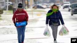 Lia Ubidia i njen sin Endru Velarde vraćaju se iz samoposluge po snegu, 15. februara 2021. 