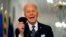 President Joe Biden holds up his face mask as he speaks about the COVID-19 pandemic during a prime-time address from the East Room of the White House, March 11, 2021.
