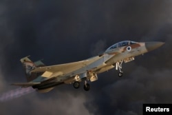 FILE - An Israeli Air Force F-15 fighter jet flies near Hatzerim air base in southern Israel, June 30, 2016. On Saturday, Israeli jets fires missiles at a suspected Iranian military base near the Syrian capital, Damascus.