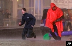 People run as weather sirens sound as a severe storm passes over downtown Dallas, Dec. 26, 2015.