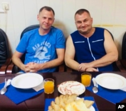 In this photo released by Roscosmos, NASA astronaut Nick Hague, left, and Roscosmos cosmonaut Alexei Ovchinin pose for a photo in Baikonur, Kazakhstan, Oct. 11, 2018, after an emergency landing following the failure of a Russian booster rocket carrying them to the International Space Station.