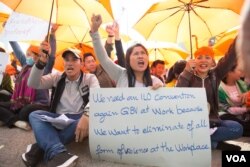 ក្រុម​សហជីព​កម្មករ​លើក​ស្លាក​មុន​នឹង​ការ​ហែក្បួន​ដាក់​ញត្តិស្តី​ពី «តម្រូវ​ការ​អាទិភាព​របស់​ស្រ្តី» អំឡុង​ទិវា​សិទ្ធិ​នារី​អន្តរជាតិ​លើក​ទី​១០៨ នៅ​ក្នុង​ពហុកីឡដ្ឋាន​ជាតិ​អូឡាំពិក កាលពី​ថ្ងៃ០៨ ខែមីនា ឆ្នាំ២០១៩។ (ទុំ ម្លិះ/VOA)