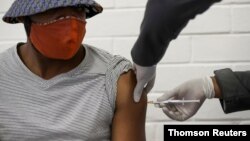 FILE - A volunteer receives an injection from a medical worker during the country's first human clinical trial for a potential vaccine against the novel coronavirus, at Baragwanath Hospital in Soweto, South Africa, June 24, 2020.