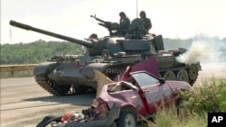 Arhiva - Hrvatski tenk prolazi pored uništenog automobila srpskih civila, nakon akcije hrvatskih snaga "Oluja", 10. avgusta 1995. (AP)