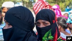 Rohingya refugees who are being moved to an island called ‘Bhasan Char’ gather outside a transit area where they are temporally housed in Ukhiya, Bangladesh, Thursday, Dec.3, 2020. 