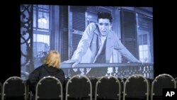 A woman watches the Elvis Presley film "King Creole" in a theater in the "Elvis Presley's Memphis" complex in Memphis, Tennessee, March 2, 2017.
