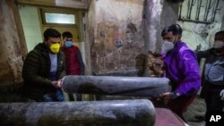 Attendants of a patient carry an oxygen cylinder inside a hospital in Srinagar, Indian-controlled Kashmir, April 25, 2021.