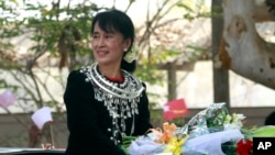 Aung San Suu Kyi menyapa para pendukung dari kendaraannya selama kampanye pemilihannya di kotapraja Bamaw, Negara Bagian Kachin, Myanmar, 24 Februari 2012. (Foto: AP)