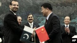 Pakistan's Prime Minister Yousuf Raza Gilani, center, and China's Premier Wen Jiabao, right, clap at a singing ceremony at the Great Hall of the People in Beijing, May 18, 2011