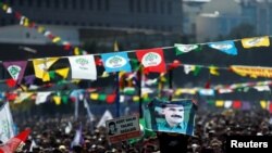 A man holds a picture of jailed Kurdistan Workers Party (PKK) leader Abdullah Ocalan as people gather to celebrate Newroz.