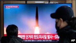 18일 한국 서울역 이용객들이 북한의 단거리 탄도 미사일과 대륙간탄도미사일(ICBM) 발사 관련 TV 뉴스를 시청하고 있다. 