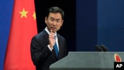 FILE - Chinese Foreign Ministry spokesman Geng Shuang gestures as he speaks during a daily briefing at the Ministry of Foreign Affairs office in Beijing, Sept. 4, 2017.