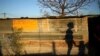 The shadows of a mother and child are cast on a shack in Marikana's Nkaneng township in Rustenburg, 100 km (62 miles) northwest of Johannesburg, August 15, 2013.