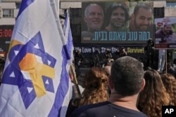Warga Israel menyaksikan siaran pembebasan Ofer Kalderon, 53 tahun, Yarden Bibas, 34 tahun, dan warga Amerika-Israel Keith Siegel, 65 tahun, yang akan dibebaskan sebagai bagian dari gencatan senjata di Gaza, di Tel Aviv, Israel, Sabtu, 1 Februari 2025. (Foto: AP/Oded Balilty)