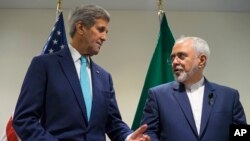 Menteri Luar Negeri AS John Kerry (kiri) dan Menteri Luar Negeri Iran Mohammad Javad Zarif di Markas Besar PBB di kota New York (26/9). (AP/Craig Ruttle)