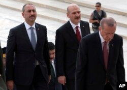 Justice Minister Abdulhamit Gul, left, and Interior Minister Suleyman Soylu, second left, follow President Recep Tayyip Erdogan during a ceremony at the mausoleum of Mustafa Kemal Ataturk, founder of modern Turkey, in Ankara, Aug. 2, 2018.