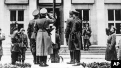 German and Russian officers salute the Nazi swastika flag during a parade in Brest-Litovsk celebrating a border demarcation in Poland on September 22, 1939, following Hitler's invasion of Poland (September 1, 1939). Brest-Litovsk, September 22, 1939