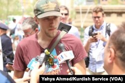 Jesse Gonzalez of Lakewood, Ohio, who carried his rifle with him, speaks to the media after arriving near the Republican National Convention in downtown Cleveland, July 18, 2016.