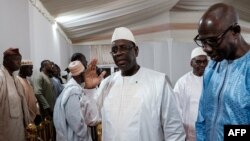FILE — Senegalese President Macky Sall, center, leaves the presidential palace in Dakar on April 28, 2023. In an address to the nation on Feb. 3, 2024, Sall announced the indefinite postponement of the presidential election scheduled for Feb. 25, 2024.