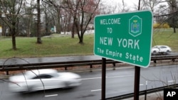 FILE - A sign welcomes motorists to New York, on the border with Connecticut, near Rye Brook, New York, March 29, 2020. 