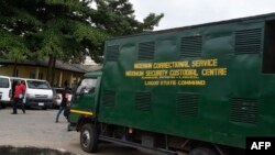 Des gens passent devant un camion utilisé pour transporter les détenus à la prison de la Haute Cour de l'État de Lagos, Ikeja, le 10 août 2020.