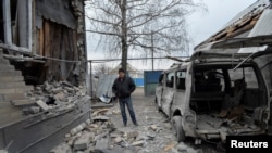 A man inspects his house, which was damaged by recent shelling, in the government-held village of Novoluhanske, Ukraine, Dec. 19, 2017. 