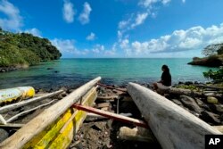 Eseta Vusamu duduk dekat pantai di Desa Faleasiu, Pulau Upolu di Samoa, 29 September 2022. Negara kepulauan seperti Samoa terancam tenggelam karena perubahan iklim mengakibatkan kenaikan permukaan laut.
