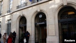 FILE - Students are seen outside Paris' Sciences Po university in Paris, France, March 15, 2016. 