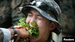 A South Korea marine eats local vegetables during a jungle survival exercise as part of the "Cobra Gold 2018" (CG18) joint military exercise, at a military base in Chonburi province, Thailand, February 19, 2018.