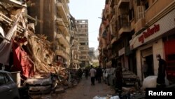 Warga berjalan melewati bangunan dan kendaraan yang hancur akibat ledakan di daerah pelabuhan Beirut, Lebanon, 5 Agustus 2020. (REUTERS / Carmen Yahchouchi)