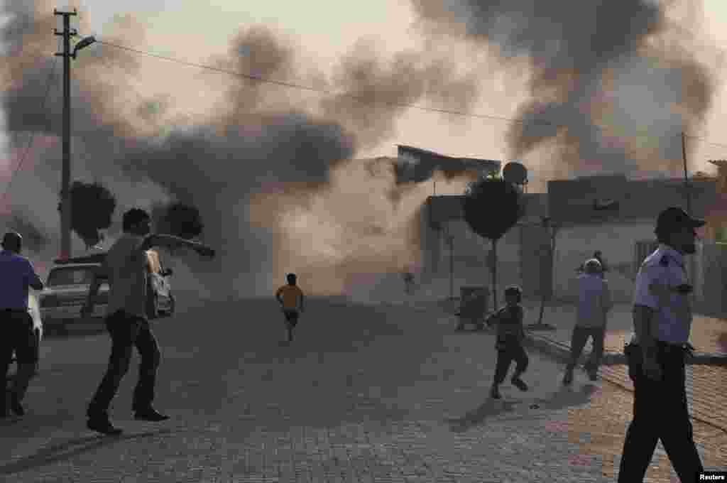 Smoke rises over the streets after an mortar bomb landed from Syria in the border village of Akcakale, Turkey, October 3, 2012. 