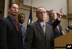 Dallas Mayor Mike Rawlings, right, takes a question as Dr. Daniel Varga, chief clinical officer at Texas Health Presbyterian Hospital, second from right, and other attend a news conference in Dallas, Oct. 15, 2014.