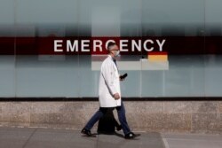 FILE - A doctor wears a protective mask as he walks outside Mount Sinai Hospital in Manhattan during the outbreak of coronavirus in New York City, April 1, 2020.