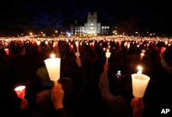 FILE - Students, friends and family hold candles up during a candle light vigil marking the second anniversary of the April 16, 2007 shootings at Virginia Tech on the campus of the school in Blacksburg, Va., Thursday, April 16, 2009. (AP Photo/Steve Helber)