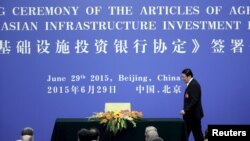 China's Finance Minister Lou Jiwei walks to sign the articles of agreement of the Asian Infrastructure Investment Bank (AIIB) at the Great Hall of the People, in Beijing, June 29, 2015.