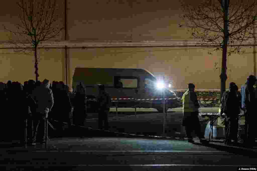 People wait in line at a food distribution point in Ventimiglia, Italy. 