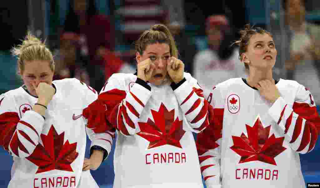 Haley Irwin, Natalie Spooner and Emily Clark of Canada react in dejection after their defeat in the women's gold medal hockey game in Gangneung, South Korea, Feb. 22, 2018.