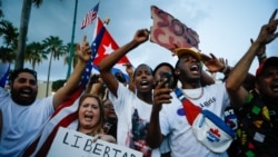 Protesters hold a sign that says "freedom for Cuba" on Sunday.