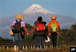 Central American migrants begin their morning trek facing Pico de Orizaba volcano as part of a thousands-strong caravan hoping to reach the U.S. border, upon departure from Cordoba, Veracruz state, Mexico, Monday, Nov. 5, 2018.