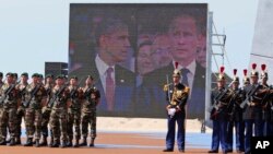 រូប​វីដេអូ​លោក​​អូបាម៉ា​និង​លោក​ពូទីន​ត្រូវ​បាន​បញ្ចាំង​នៅ​លើ​អេក្រង់​ធំ​មួយ​ខណៈ​ដែល​ពួក​លោក​ចូល​អង្គុយ​នៅ​ក្នុង​ពិធី​រំលឹក​ខួប​ទី​៧០​នៃ​ទិវា D-Day។