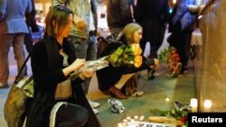 People place flowers at a makeshift memorial to pay tribute to the victims of the terror attack in Paris outside the Consulate General of France in San Francisco, California, Nov. 13, 2015.