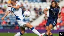 France's Camille Abily, left, attempts to stop a shot by United States' Tobin Heath during the women's group G soccer match between the United States and France prior to the start of the London 2012 Summer Olympics at Hampden Park Stadium in Glasgow, July